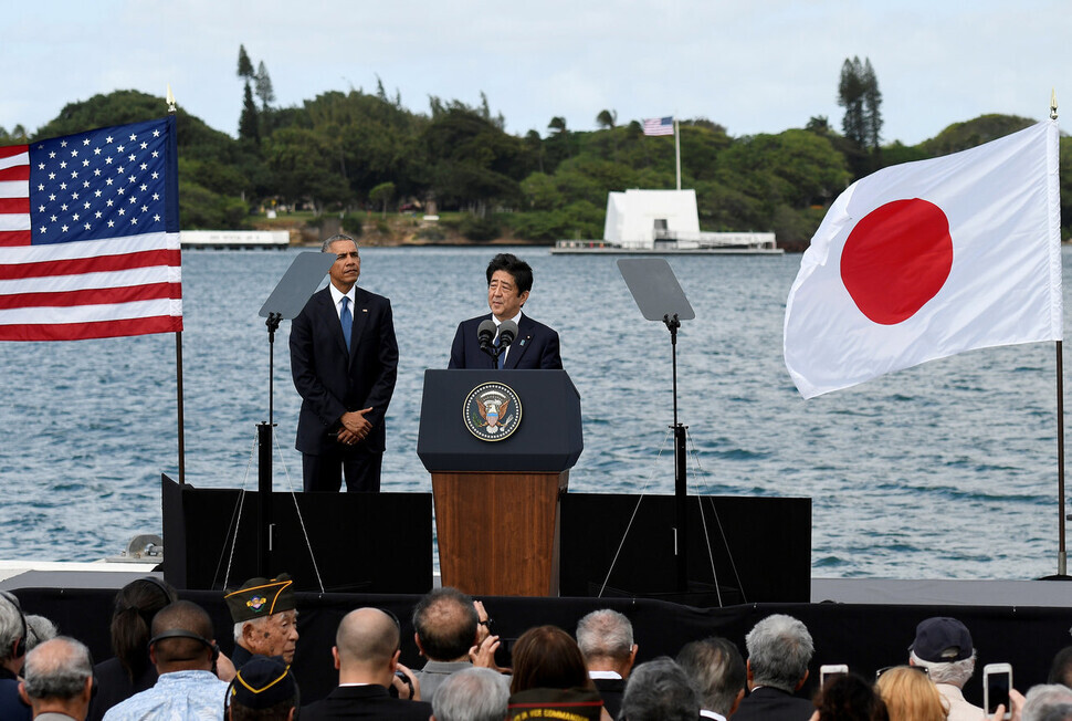 Then-Japanese Prime Minister Shinzo Abe makes a speech during a visit to Pearl Harbor in Honolulu, Hawaii, on Dec. 27, 2016, as then-US President Barack Obama looks on. A memorial to the USS Arizona, a battleship sunk in Japan’s surprise attack on Pearl Harbor on Dec. 7, 1941, can be seen in the background of the photo, on the right side. (Reuters/Yonhap News)