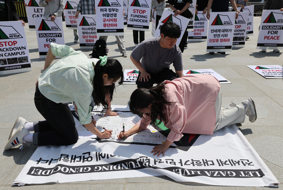 Students organizing themselves under the name Student Action for Peace write messages of solidarity on a banner during their rally outside the US Embassy in Seoul on May 10, 2024. (Kim Young-won/The Hankyoreh)