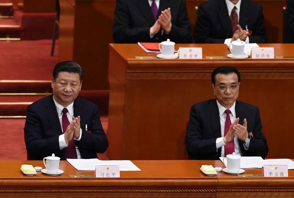 Chinese President Xi Jinping (left) and Premier Li Keqiang applaud during the closing ceremony of the National People’s Congress at the Great Hall of the People in Beijing