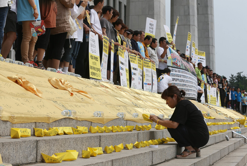 2014년 7월13일, 세월호 유족들이 서울 여의도 국회의사당 앞에서 희생자와 실종자들의 이름이 적힌 노란 종이배를 세워놓은 채 세월호 특별법 관련 기자회견을 하고 있다. 이정우 선임기자