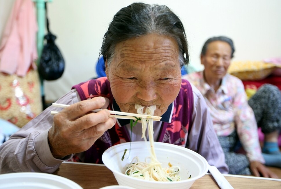 장경순 할머니가 마을회관에서 제공하는 국수를 먹고 있다.