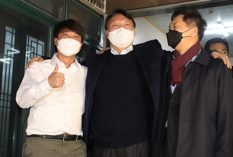 People Power Party presidential nominee Yoon Seok-youl (center) puts his arms around the shoulders of People Power Party leader Lee Jun-seok (left) and floor leader Kim Gi-hyeon (right) after meeting at a restaurant in Ulsan’s Ulju County on Friday. (Yonhap News)