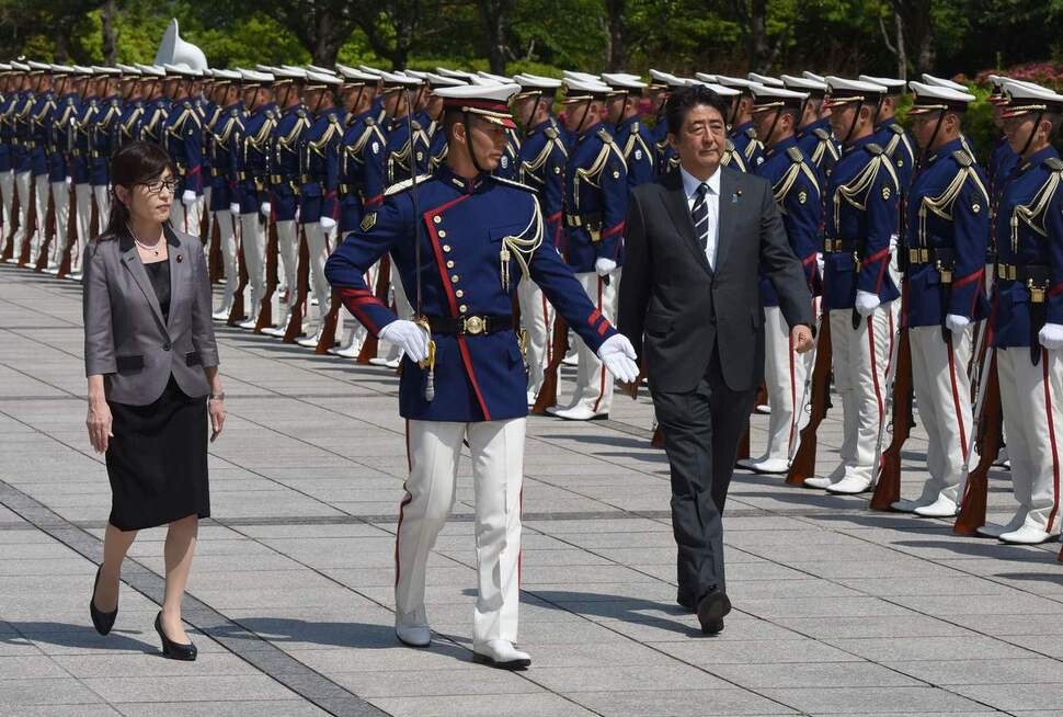 Japanese Prime Minister Shinzo Abe and Minister of Defense Tomomi Inada observe an honor guard at the Defense Ministry in Tokyo. (AFP/Yonhap News) 　