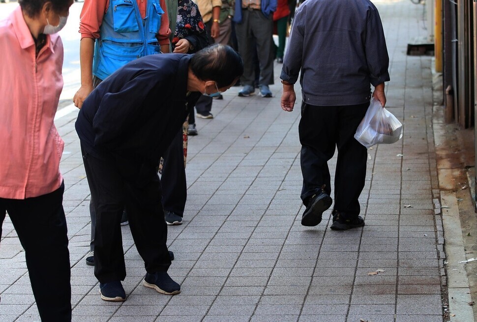 A person waiting in line at a soup kitchen in Anyang on Oct. 5, 2022, turns back to see what that day’s lunch bag held. (Park Jong-sik/The Hankyoreh)