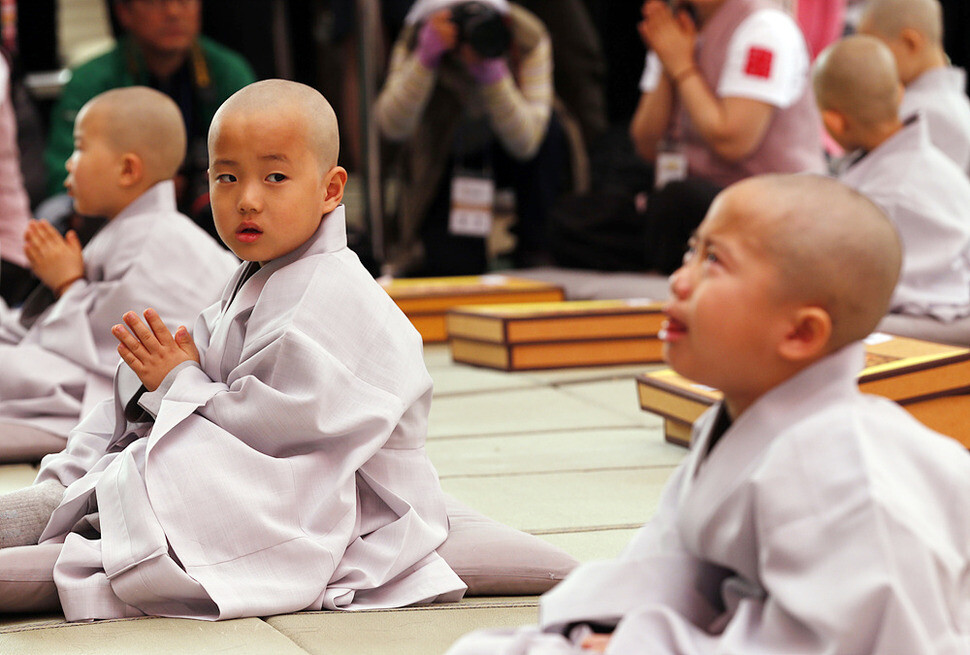 The boy is comforted by a senior monk. (by Lee Jong-geun