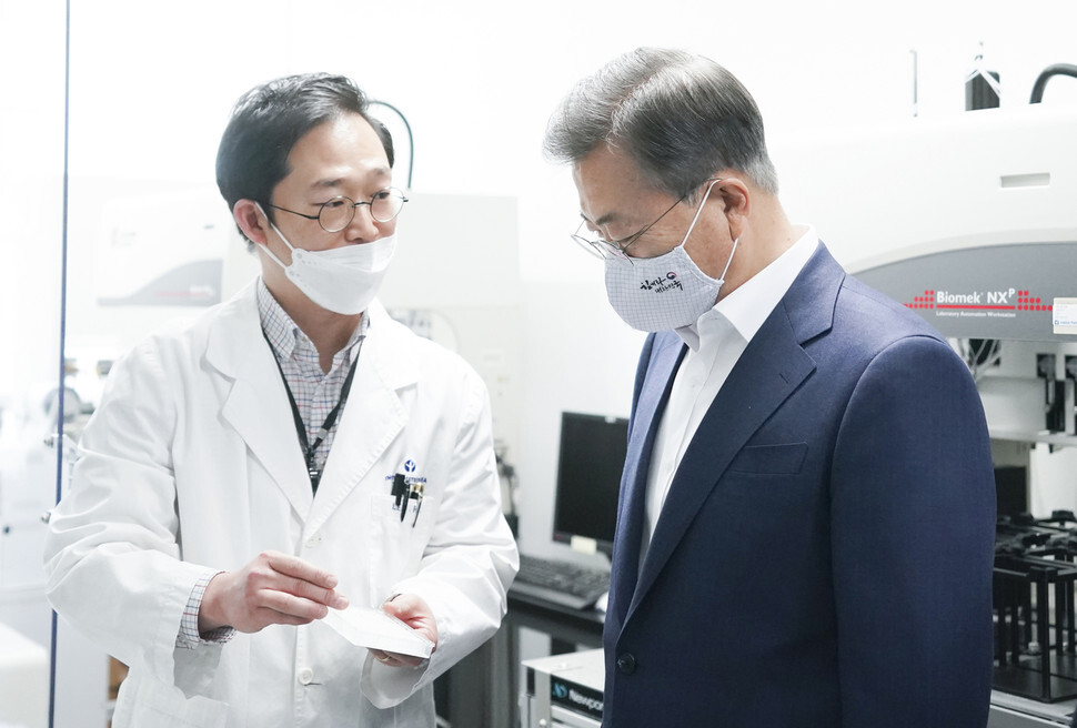 Lee Hong-geun, senior research fellow at the Institut Pasteur Korea in Seongnam, Gyeonggi Province, explains the processing of certain compounds to South Korean President Moon Jae-in on Apr. 9. (Blue House photo pool)