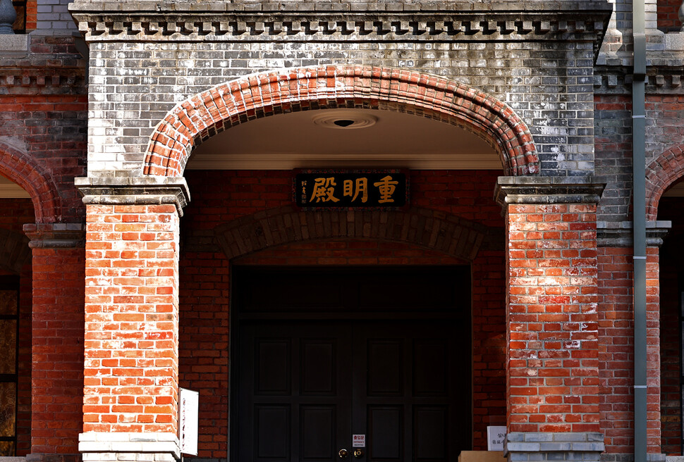 회색과 붉은색 벽돌이 섞인 덕수궁 중명전 들머리. 편액에 ‘명’(眀) 자가 ‘일’(日)이 아닌 ‘목’(目)으로 쓰였다.