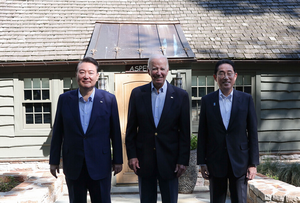 South Korean President Yoon Suk-yeol, US President Joe Biden, and Japanese Prime Minister Fumio Kishida stand for a photo outside the Aspen Lodge at Camp David, the US presidential retreat in Maryland, on Aug. 18 following their trilateral summit. (pool photo)