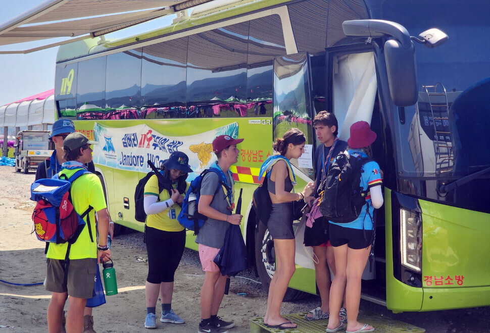 Participants in the World Scout Jamboree in Saemangeum, North Jeolla Province, wait in line on Aug. 7 for an air-conditioned bus brought in as part of heat-relief efforts by the province’s fire service.