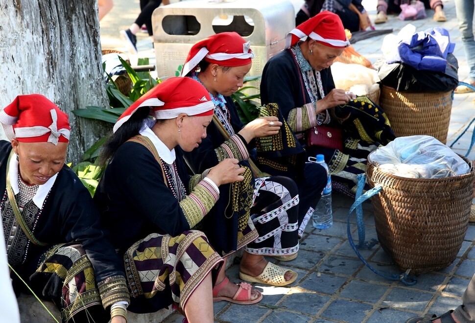 사파 광장에서 자오족 여성들이 전통 천에 수를 놓고 있다. 
