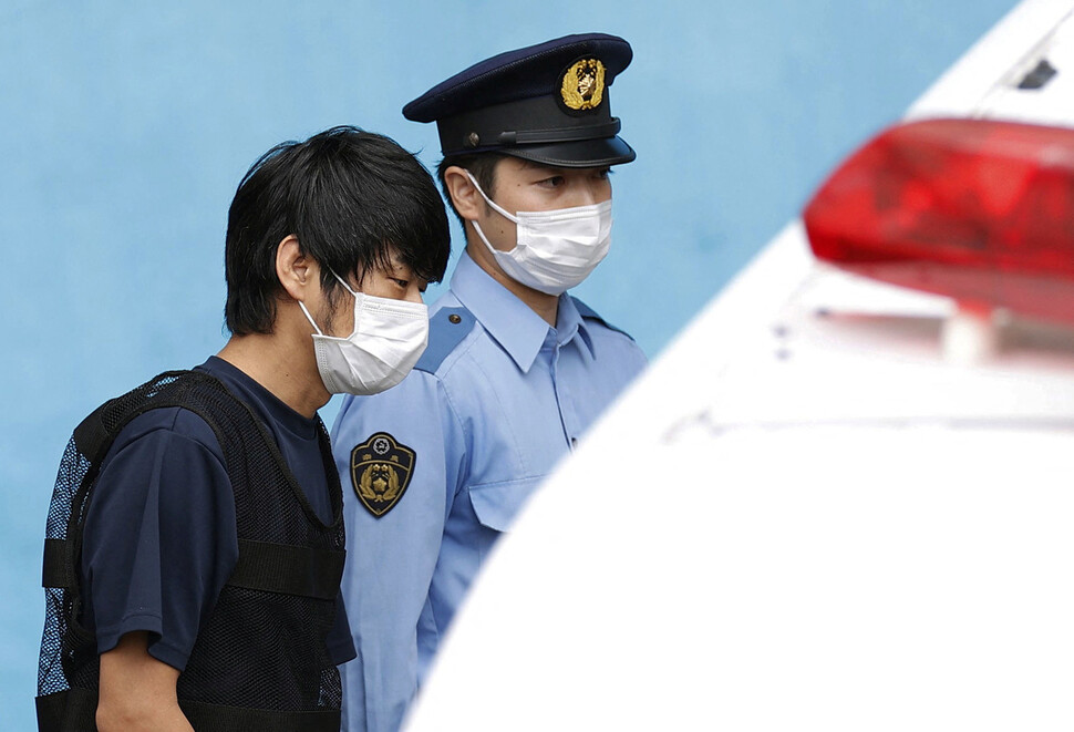 아베 전 일본 총리를 살해한 혐의를 받는 야마가미 데쓰야가 일본 나라니시 경찰서에서 경찰의 호위를 받고 검찰로 이송되고 있다. 도쿄/로이터 연합뉴스