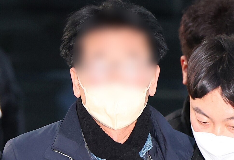 The man apprehended for attacking Democratic Party leader Lee Jae-myung, a 67-year-old individual surnamed Kim, is taken to the Busan Metropolitan Police Agency. (Yonhap)