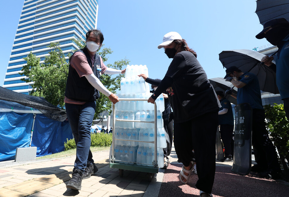 민주노총이 원주 집회를 계획한 23일 집회 장소인 원주시 국민건강보험공단 인근에서 노조원들이 생수를 옮기고 있다. 연합뉴스