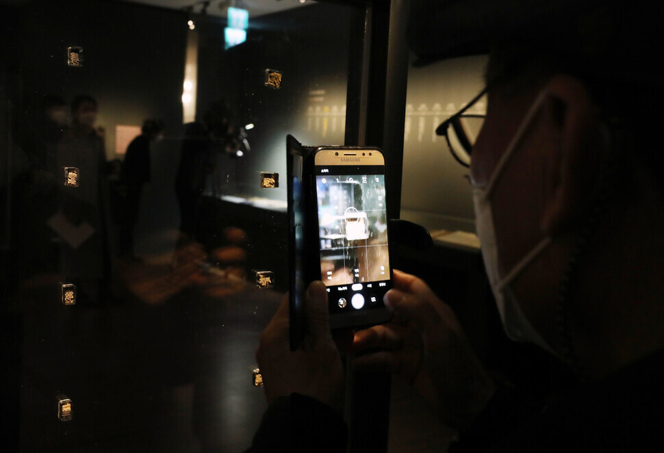 One museum-goer snaps a picture of the metal movable type displayed on the first floor of the National Palace Museum of Korea in Seoul’s Jongo District. (Kim Hye-yun/The Hankyoreh)