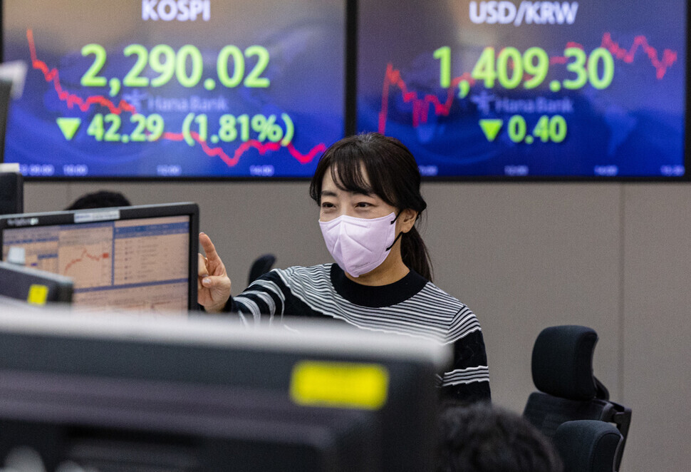 A trader can be seen working in Hana Bank’s dealing room in downtown Seoul on Sept. 23, with the closing figures for KOSPI and the exchange rate shown on monitors in the background. (Yonhap)