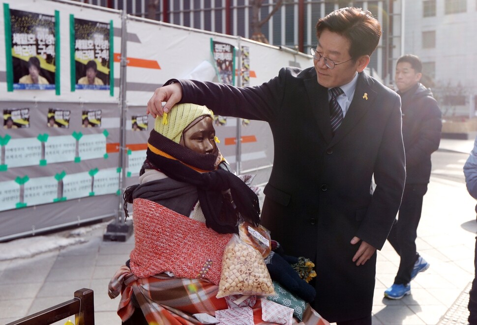 Seongnam Mayor Lee Jae-myung touches the comfort woman statue across from the Japanese embassy in Seoul’s Jongno district