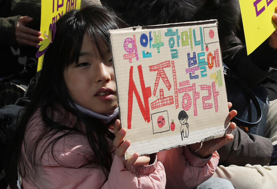 A young participant in the 1,584th Wednesday Demonstration in Seoul holds up a sign reading “Apologize to the ‘comfort women’ grannies.” (Shin So-young/The Hankyoreh)