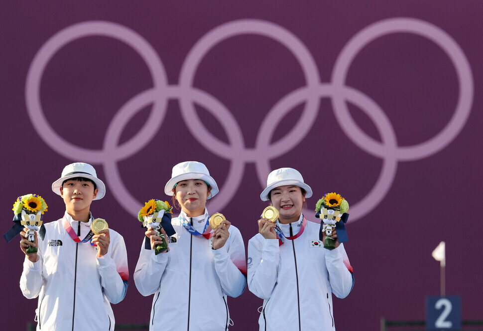 An San (left), Jang Min-hee (center) and Kang Chae-young of the Korean women’s archery team pose for a photo with their gold medals for the women’s team event at the Tokyo Olympics on Sunday at the Yumenoshima Park Archery Field in Tokyo. (Kim Myoung-jin/The Hankyoreh)