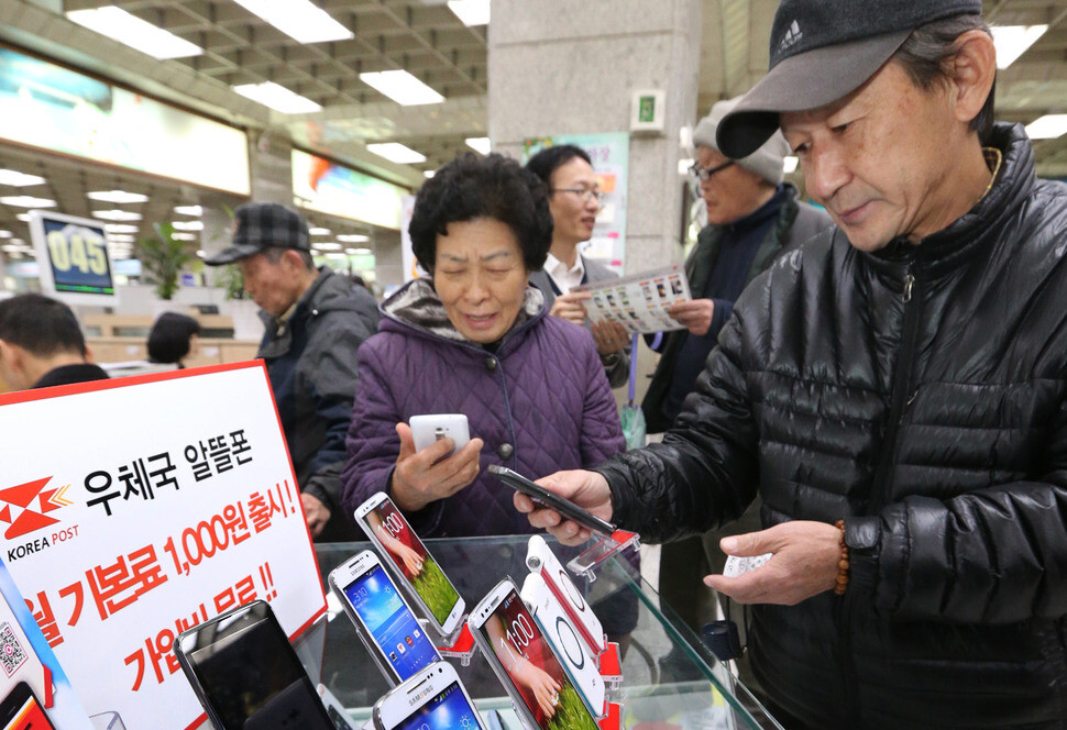 우체국은 2013년 월 기본료 1천원의 알뜰폰 요금제를 선보였다. 어르신들이 알뜰폰을 살펴보고 있다. 연합뉴스