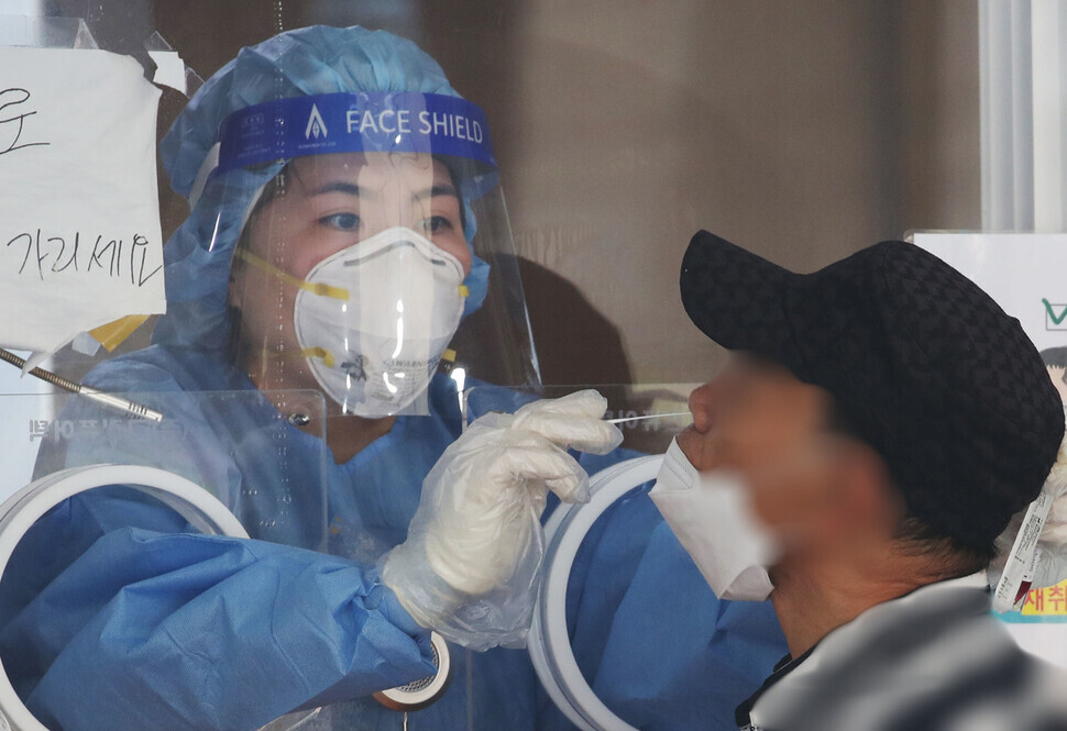 A person gets tested for COVID-19 at a temporary screening station in Seoul on Wednesday. (Yonhap News)