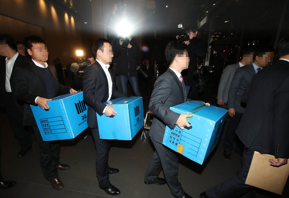 Prosecutors carry boxes of documents seized from Samsung Electronics headquarters in Seoul’s Seocho district