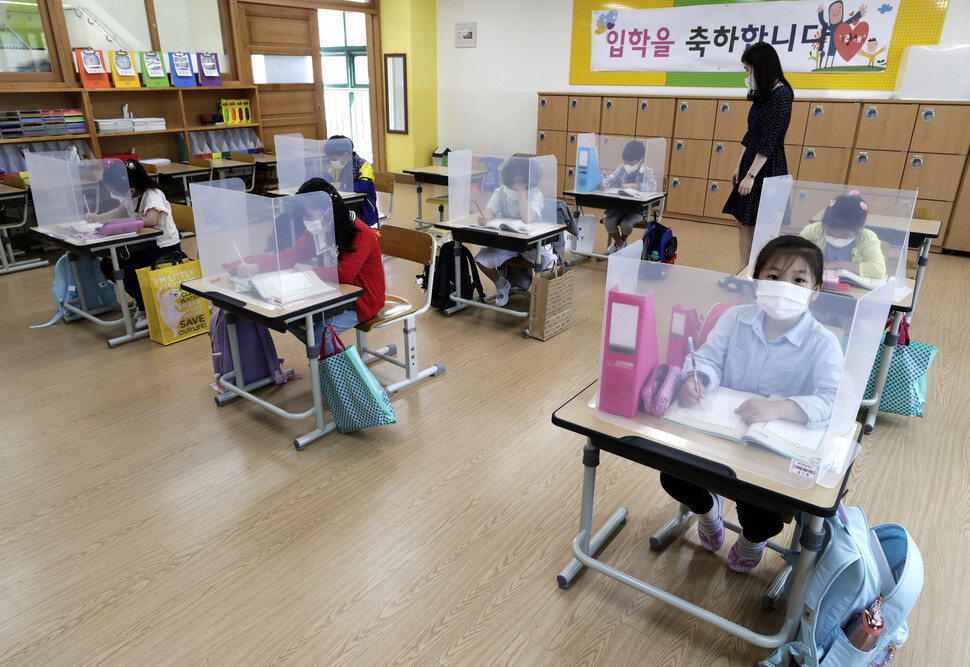 First graders at an elementary school in Paju, Gyeonggi Province, sit at individual desks protected by plastic barriers. (Kim Myoung-jin, staff photographer)