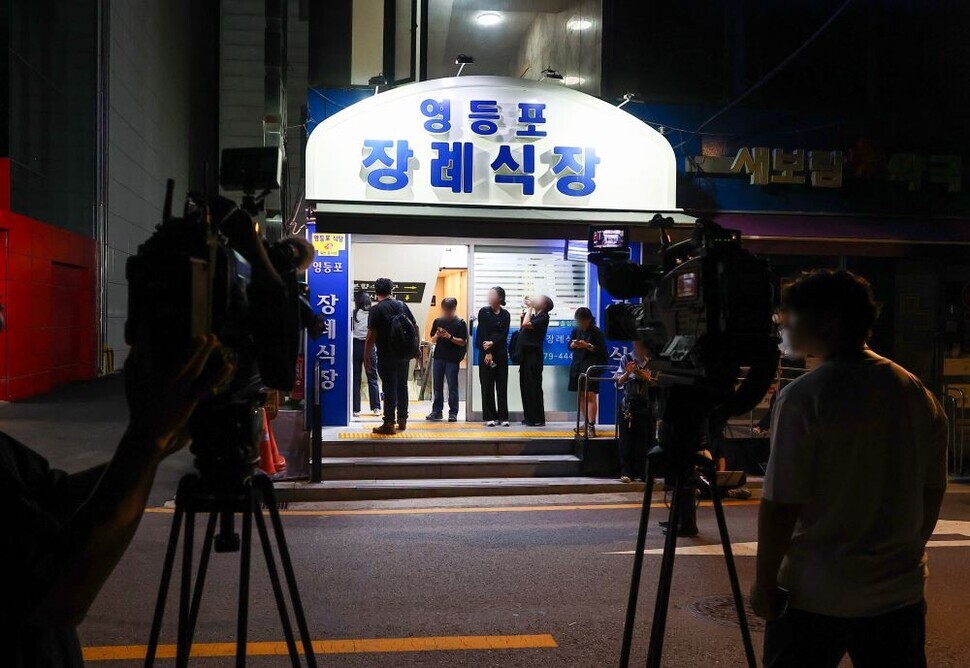 Reporters with various outlets stand outside the Yeongdeungpo Hospital’s mortuary in the early hours of July 2, 2024, where those killed in the crash were transported. (Yonhap)