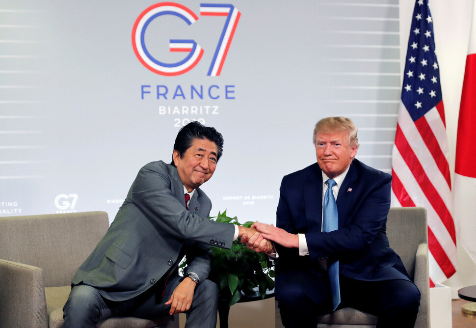US President Donald Trump and Japanese Prime Minister Shinzo Abe shake hands at the G7 summit in Biarritz