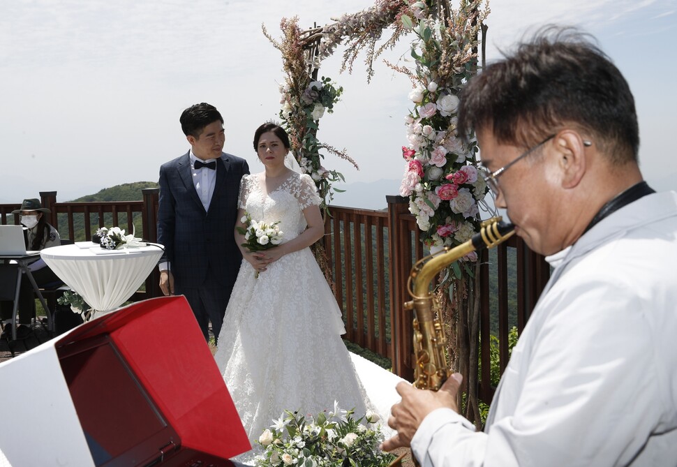 국립공원공단에 근무했던 박노준씨(오른쪽)가 축하 연주를 하는 동안 신랑이 신부를 바라보고 있다.