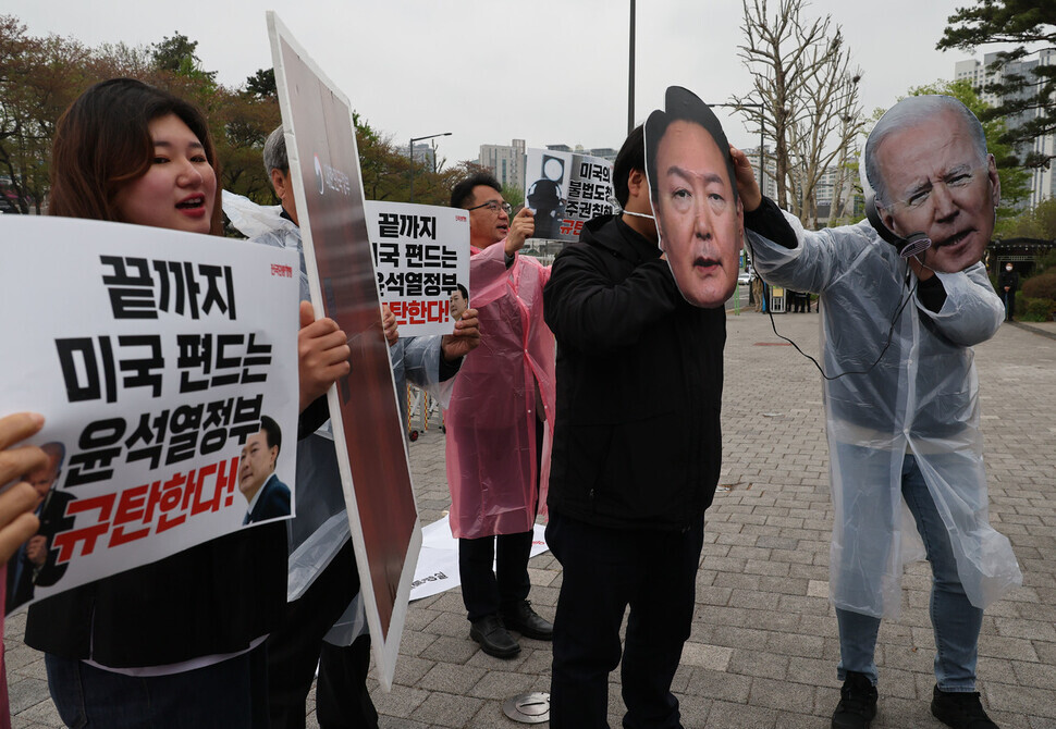 Participants in a press conference condemning the US for allegations of spying on Korea, as well as condemning the Korean response to the allegations, hold up signs and wear masks depicting the faces of the South Korean and US leaders outside the presidential office in Yongsan on April 11. (Shin So-young/The Hankyoreh)