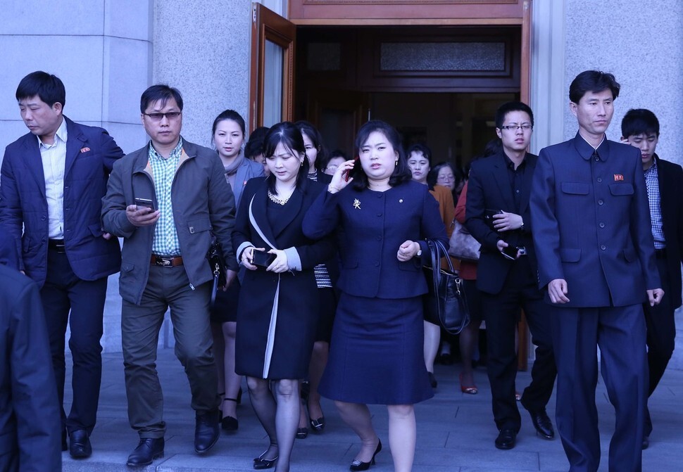 North Koreans with mobile phones in hand exit Pyongyang Grand Theatre after attending the April Spring Friendship Art Festival