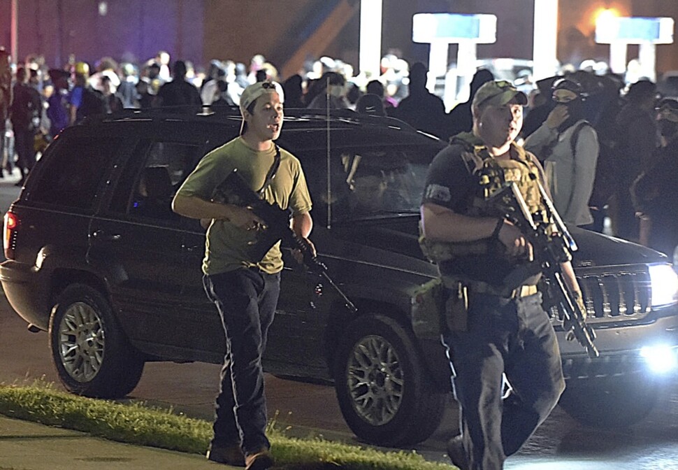 17살 백인 소년 카일 리튼하우스(앞줄 왼쪽)가 8월25일 밤 자동소총으로 무장한 채 커노샤의 셰리던 거리를 걷고 있다. 그가 이날 밤 인종차별 반대 시위대에 총격을 가해, 2명이 숨졌다.