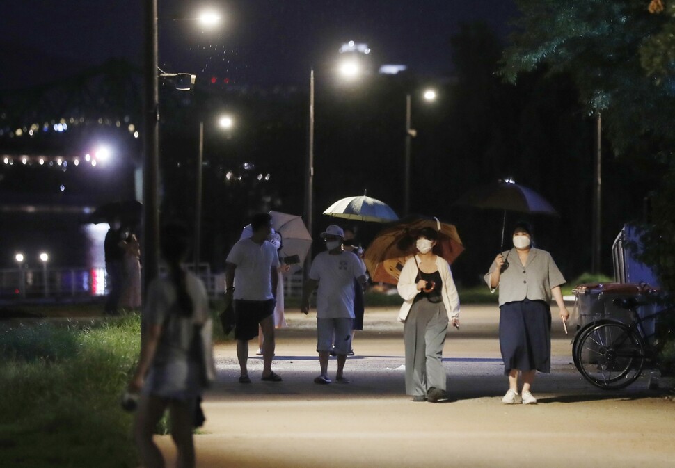 10시28분, 갑작스레 굵은 소나기가 내리자 사람들이 우산을 받쳐들고 있다.