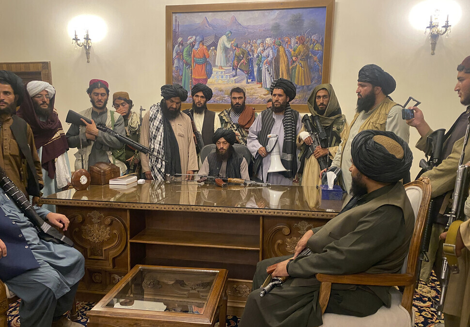Taliban fighters take control of the Afghan presidential palace in Kabul, Afghanistan, on Sunday after president Ashraf Ghani fled the country. (AP/Yonhap News)