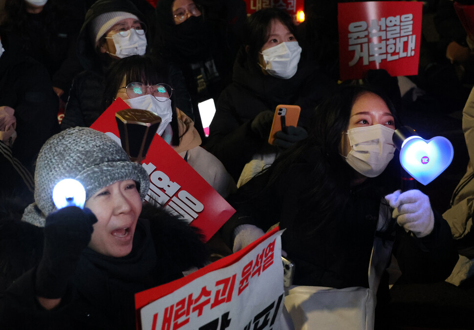 더보이즈 응원봉을 든 시민(오른쪽)이 가족과 함께 탄핵을 외치고 있다.