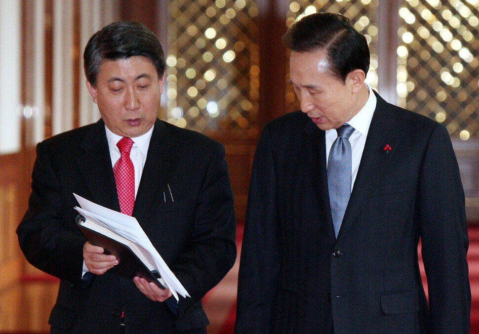 On Dec. 9, 2009, President Lee Myung-bak is briefed by Lee Dong-kwan, his press secretary, ahead of attending a meeting at the Blue House on strengthening the competitiveness of the Korean economy. (Blue House pool photo)