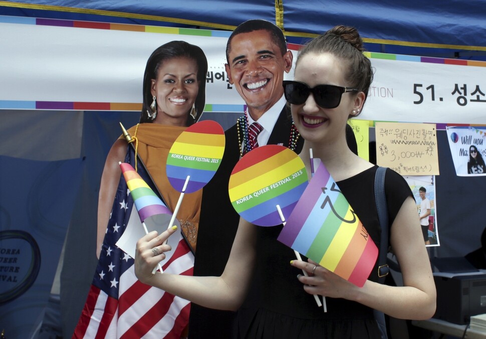 A participant in the 2015 Seoul Queer Culture Festival poses in front of cut-outs of Barack and Michelle Obama at the US Embassy booth. (AP/Yonhap News)