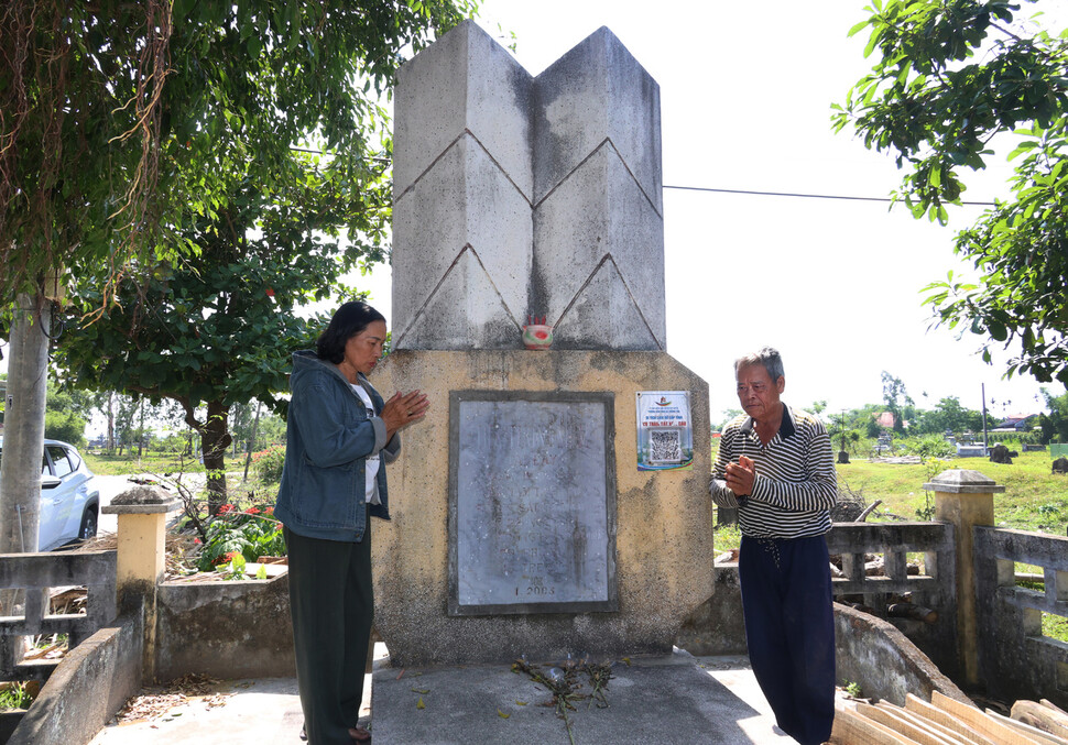 베트남 꽝남성 반꾸엇 학살 생존자 응우옌티씨와 쯔엉떤트엉이 2025년 4월28일 당시 숨진 가족들의 이름이 새겨진 위령비 앞에서 두 손을 모아 추모하고 있다.