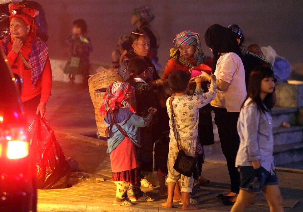안개가 짙게 드리운 지난 4월29일 밤, 사파 광장 근처에서 고산족 주민들이 동전지갑과 천팔찌 등을 꺼내들고 관광객에게 팔고 있다. 
