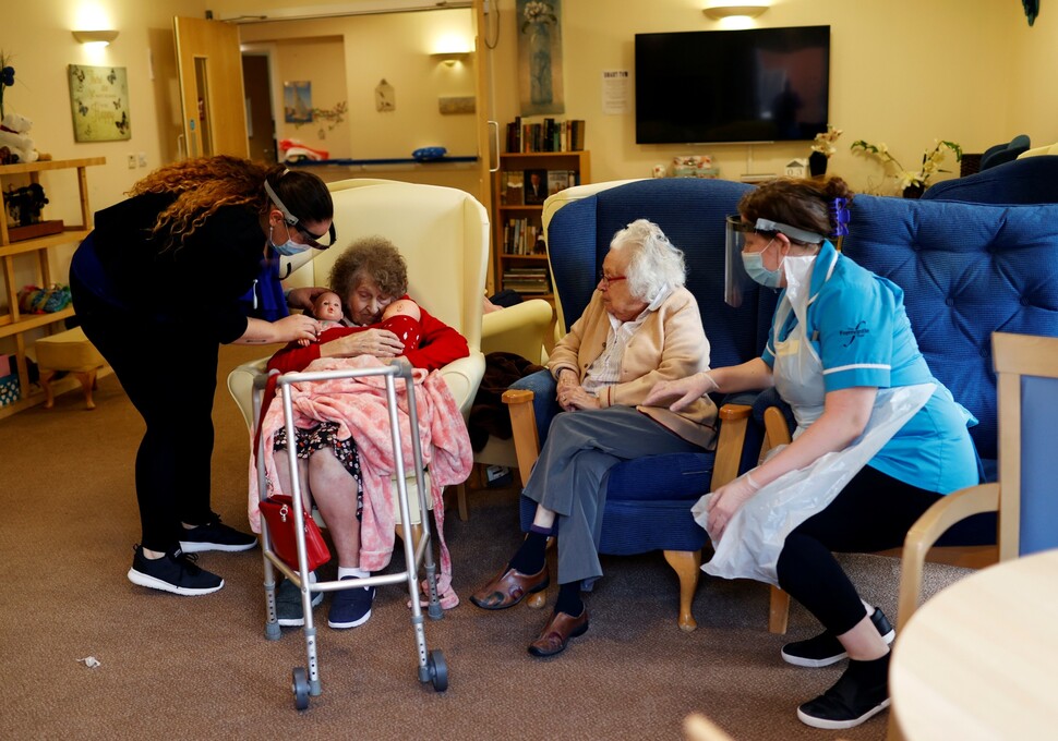 2020년 5월 코로나19 확진자가 나온 영국의 한 요양원에서 간병인이 환자들과 이야기를 나누고 있다. REUTERS