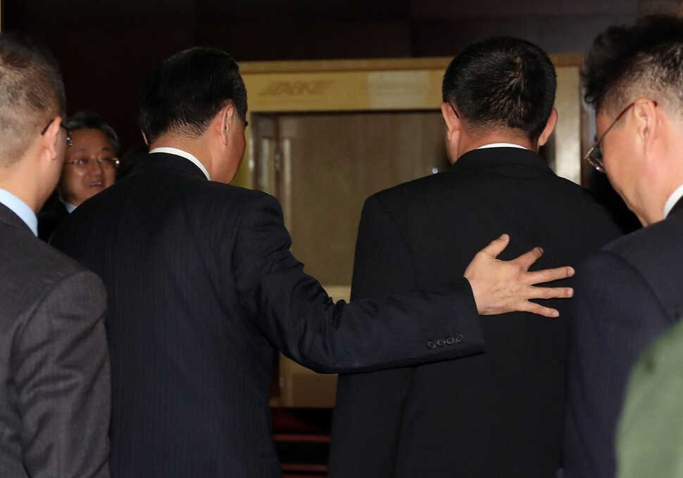 Chinese Foreign Minister Wang Yi (left) places his hand on the back of his North Korean counterpart Ri Yong-ho at the front of their meeting room at the International Convention Center in the Laotian capital of Vientiane on July 25. (Yonhap News)