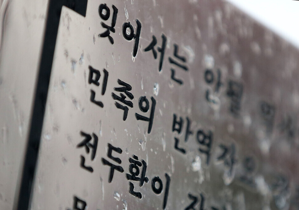 On Tuesday, raindrops fall on a placard at the entrance to the Mangwol cemetery erected by an association of people from Gwangju and South Jeolla Province who took part in democracy protests. (Kim Hye-yun/The Hankyoreh)