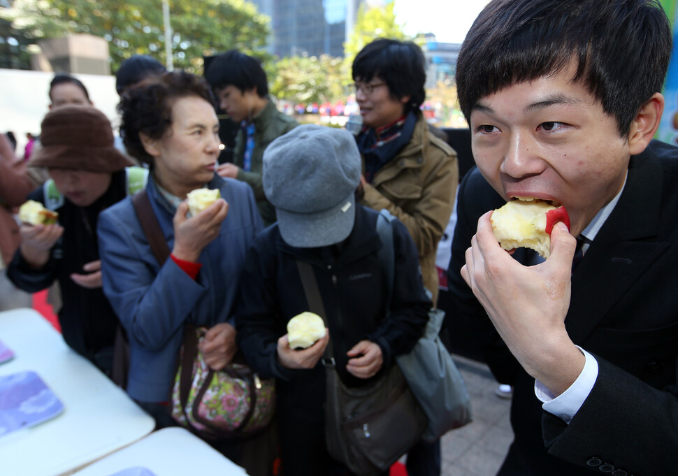 서울 성동구 서울숲에서 열린 경북 영주 사과 홍보 행사에서 시민들이 사과 빨리 먹기 시합을 즐기고 있다. 연합뉴스