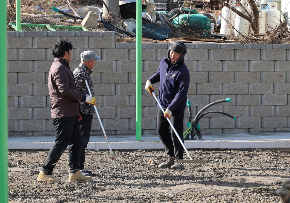 김민욱씨(오른쪽)가 대이작도 이작1리 마을 빈터에 족구장을 만드느라 주민들과 함께 땅을 고르고 있다.