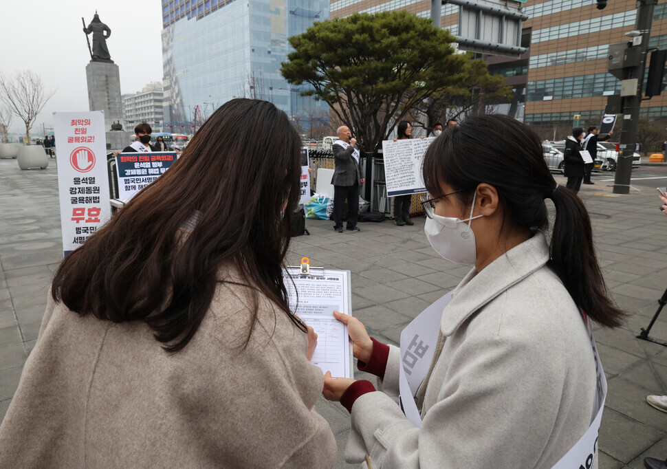 A person signs their name to Joint Action for Historical Justice and Peaceful Korea-Japan Relations’ signature campaign to void the Yoon Suk-yeol administration’s proposed plan for compensating victims of Japan’s forced labor mobilization. (Kim Hye-yun/The Hankyoreh)