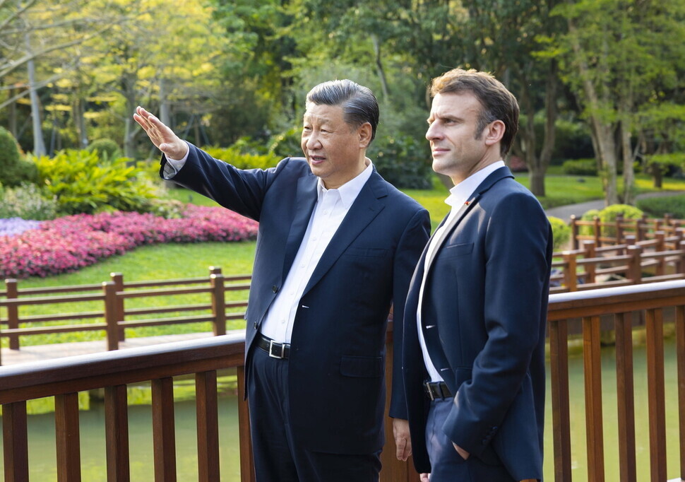 President Xi Jinping of China speaks with President Emmanuel Macron of France as they walk through the Pine Garden in Guangzhou, in Guangdong Province, during the latter’s visit to China on April 7. (EPA/Xinhua/Yonhap)