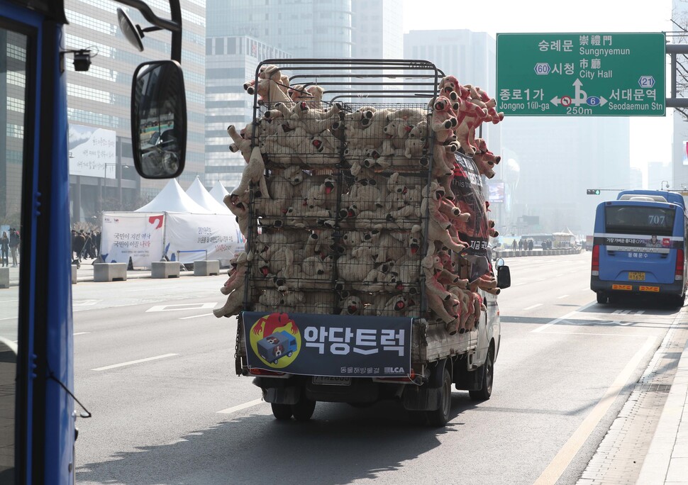 2022년 7월 서울 세종로에서 동물해방물결 회원들이 개를 도살장과 경매장으로 실어나르는 트럭을 재연한 ‘악당트럭’을 운행하며 ‘동물 임의도살 금지법 통과’를 촉구하고 있다. 한겨레 박종식 기자