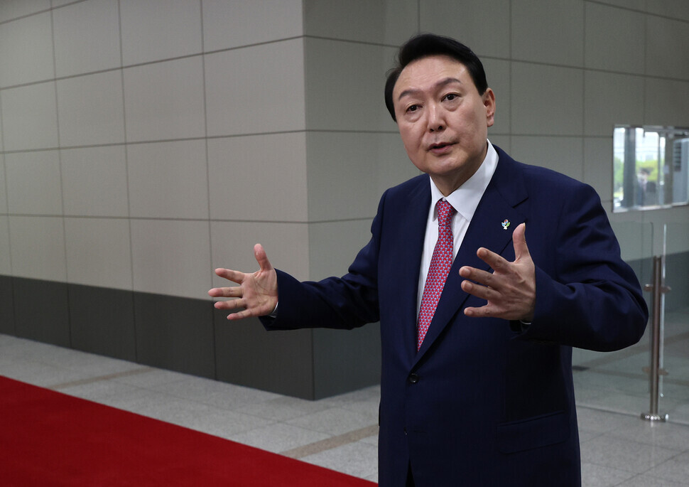 President Yoon Suk-yeol answers questions from reporters while commuting to the presidential office in Yongsan, Seoul, on June 23, 2022. (pool photo)