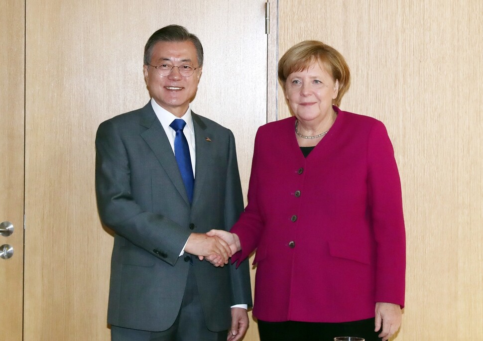 South Korean President Moon Jae-in shakes hands with German Prime Minister Angela Merkel following the Asia-Europe Meeting (ASEM) in Brussels