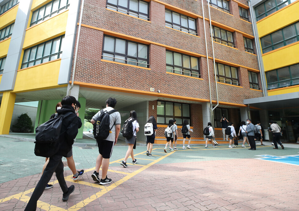 Students at a middle school in Seoul enter their school building while conforming to social distancing rules on June 14. (Yonhap News)